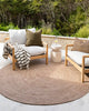 Two chairs sit outside on top of a warm brown rug by Baya NZ