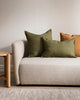 The Baya Cassia and Arcadia linen cushions in miltary green, shown on a contemporary couch