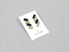 Acrylic geometric designer earrings in gold and matte black, on a card