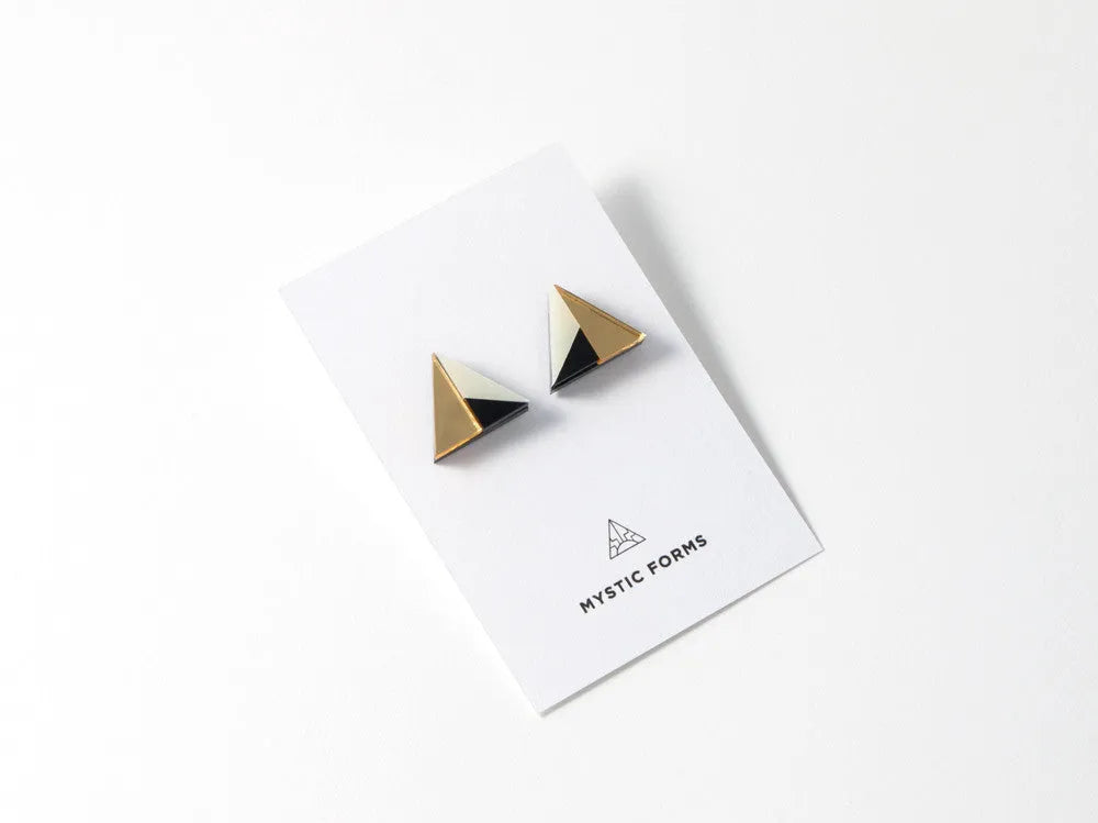 Gold, black and ivory triangular acrylic earrings by Mystic Forms, seen on a card