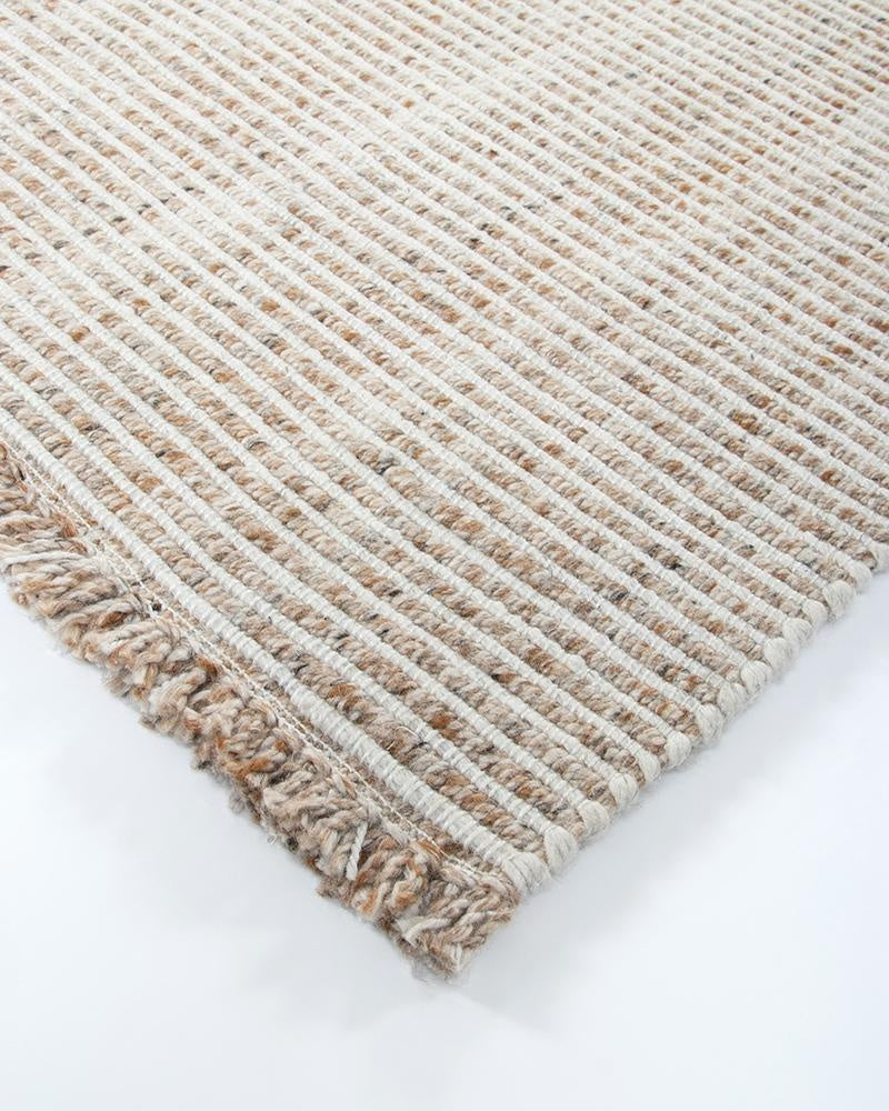 A close up of the Rhodes Teak outdoor runner rug, highlighting the cream and brown weave and fringe detail