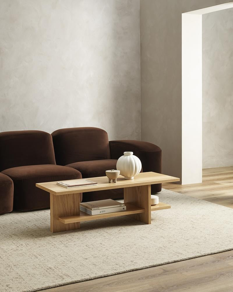 The Baya 'Cadence Camel' pure wool floor rug in brown and beige, seen in a modern minimalist living room.