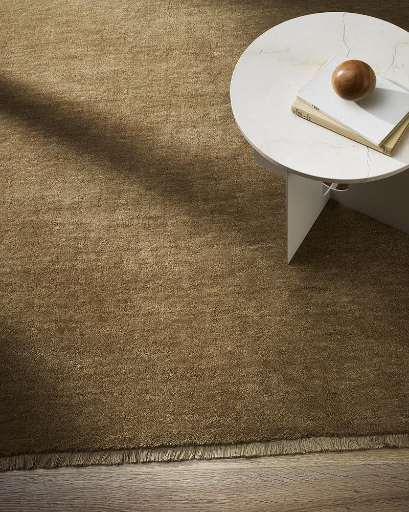 The light-mid brown 100% wool Sandringham floor rug by Baya, seen from above in a stylish nz living room.