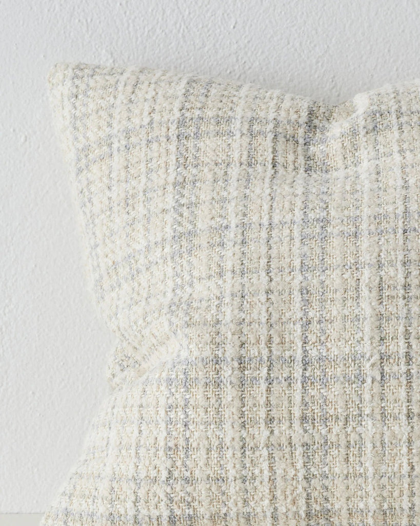 Close up of a stylish woven cushion in white, alongside subtle beige and blue - the Tripoli Pearl by Weave, highlighting the textural weave.