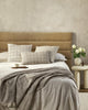 Beautiful cream and beige designer cushions by Baya, on a bed in a stylish modern bedroom.