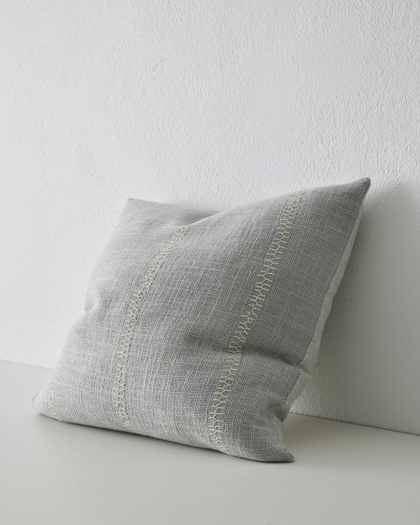 Angle view of a pale blue cushion with while embroidered stripe, by Weave Home nz