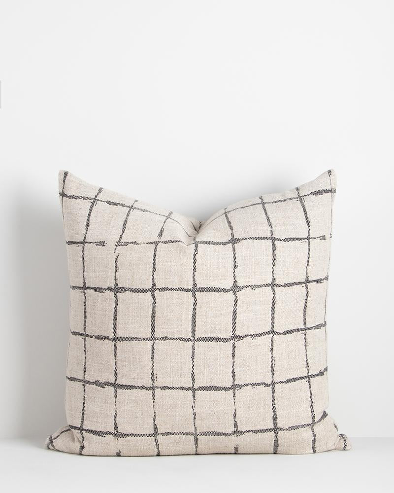 The modern patterned Harrison cushion in black by Baya, featuring a grey/black grid design in a hand-painted style on a natural linen-look base.