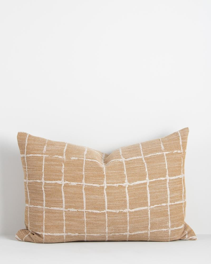 A stylish, geometric lumbar cushion featuring a grid pattern in a hand-painted style, and an earthy ochre  colour with white.