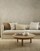 Baya designer cushions in ecru, ochre and brown tones, styled together on a couch in a stylish minimalist living room.