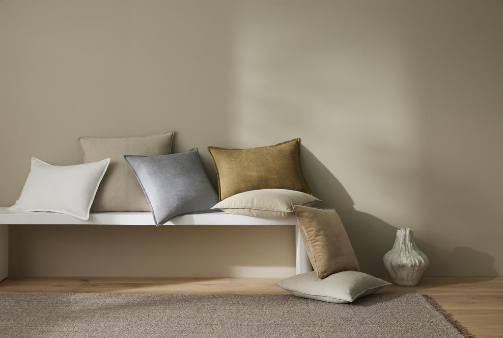 Beautiful Fiore cushions in sophisticated colours, by Weave Home, scattered across a bench seat.