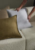 Three Fiore cushions in on-trend colours, by Weave Home, being placed on a cream boucle couch.