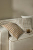 Feature cushions with a bold textural weave in warm colours and white, in a stylish home