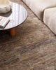 A stylish modern living room with a textural bamboo silk and jute floor rug in shades of warm grey and natural jute brown, by Baya