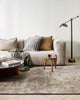 A living room with a textured handmade floor rug in shades of warm grey and honey brown, made with natural jute fibres  and bamboo silk by Baya. 