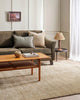 A living room in warm earth tones with a soft sandy beige rug, made with bamboo silk and durable natural jute fibres by Baya