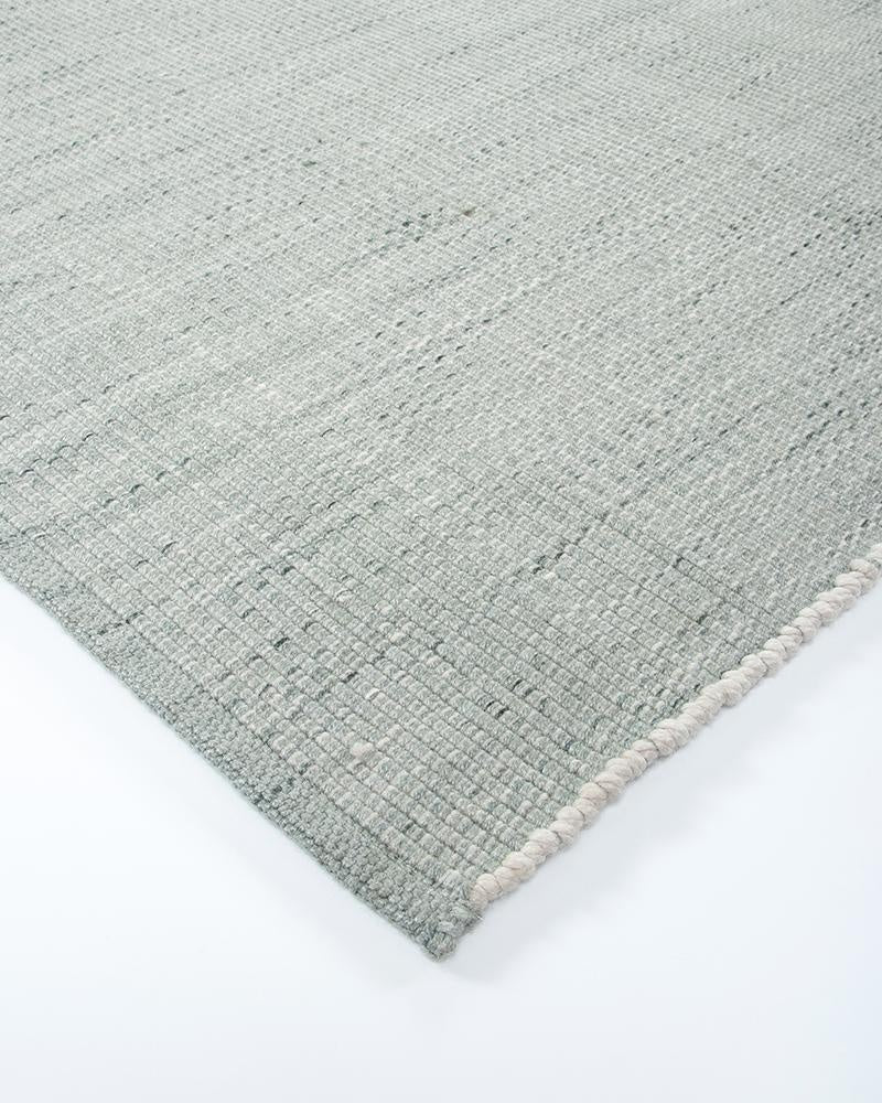 Close up view of the corner of the Baya green Lonsdale outdoor rug, showing the textural weave.