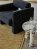 The  Bower Frame 100% wool floor rug in moss green, seen under a designer chair