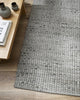 Close up of the grey Pelorus indoor or outddor rug by Baya, seen inside on wooden floorboards