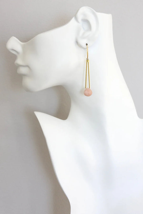 David Aubrey Peachy pink moonstone dangle earrigns with gold plated hooks and brass tubes, seen on a model