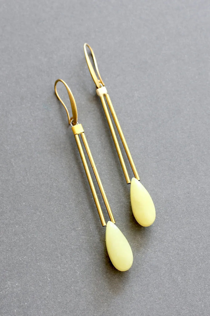 Elegant yellow jade dangle earrings with brass tubes and gold plated hooks, by David Aubrey, seen flat