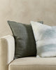 The Baya Flaxmill pure linen cushion in Sage Green next to the Baya Sunset cushion, on a couch close up