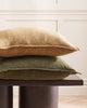 A coffee table with two cushions on it, both in a gorgeous textured linen, one a deep rosemary green and one in a soft yellow beige. By Baya