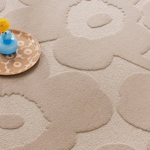 Marimekko's iconic Unikko design features on this wool floor rug in a light beige colour.