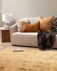 A modern living room featuring warm toned cushions on a cream couch with the Baya Brunswick nz wool throw