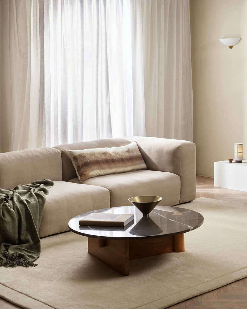 A neutral living room with a beautiful cut pile floor rug in a creamy ivory white, with frame detailing around the edges, by Baya in 100% New Zealand wool.