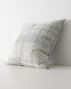 A side long image of a square cushion with a textured check pattern in shades of muted light blue and white. 