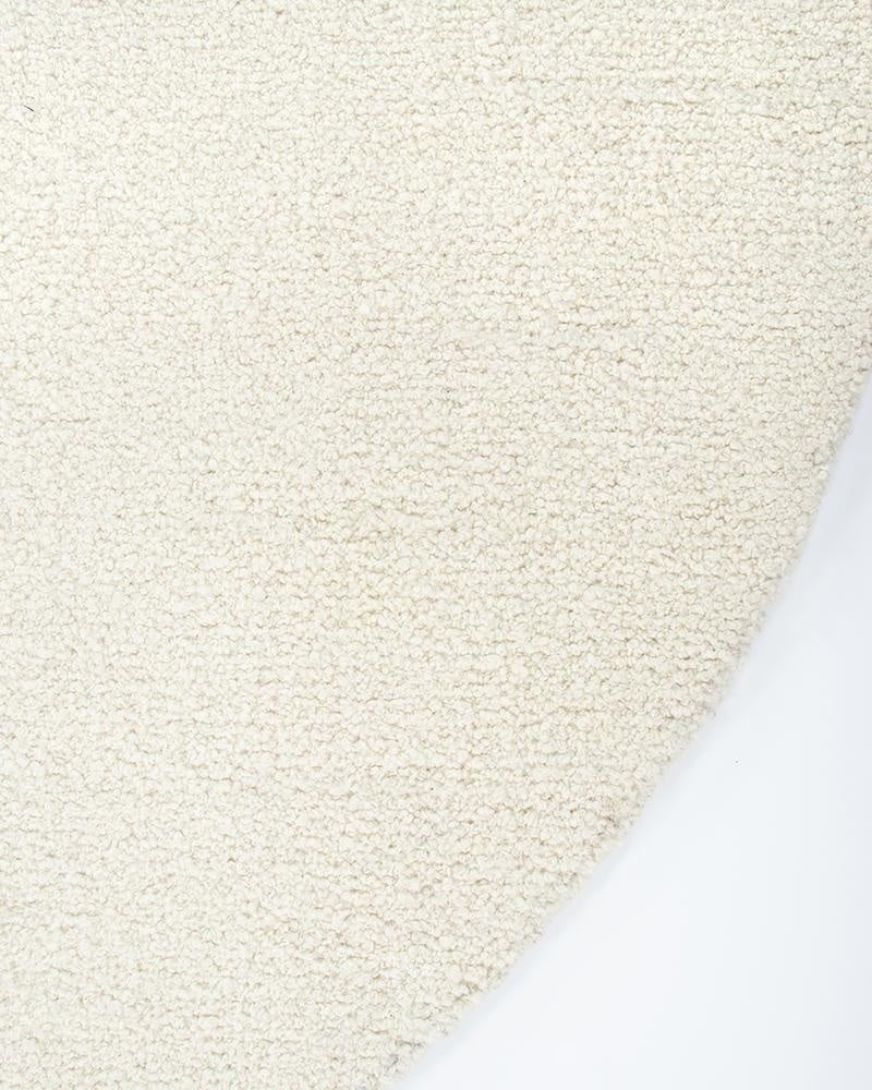 The beautiful Dorset Natural White boucle-style floor rug by Baya, seen close up from above at the curved edge