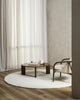 The round, Dorset, boucle weave wool and merino floor rug by Baya in a natural white seen in a modern living room