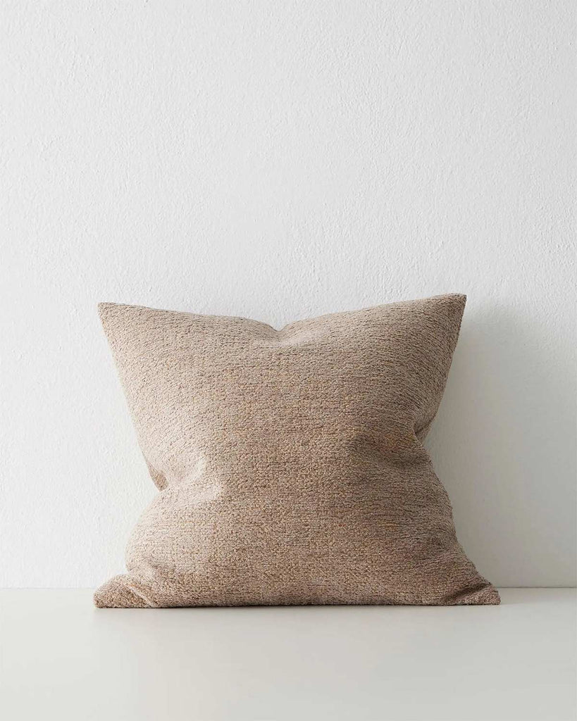 A softly textured light brown cushion. 