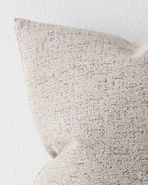 A detailed view of the corner of a softly textural taupe cushion. 