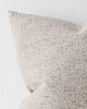 A detailed view of the corner of a softly textural taupe cushion. 