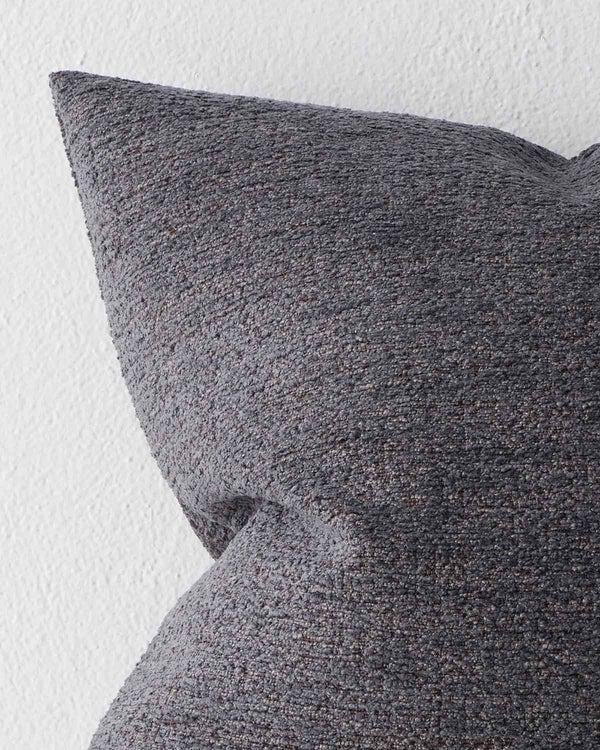 A detailed view of a textural cushion in a deep muted navy blue tone. 