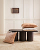 Three cushions on and around a coffee table, two in a stylish textural linen and one striped velvet in a muted clay pink. 