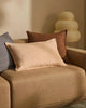 Pale pink lumbar cushion with flange detail, the Fiore Nectar , seen on a brown couch in a stylish living room