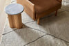 A plush, cream wool rug with diamond detail, seen in a modern living room