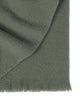A folded soft wool blend throw blanket, with fringed edges, in a delicate shade of muted green. 