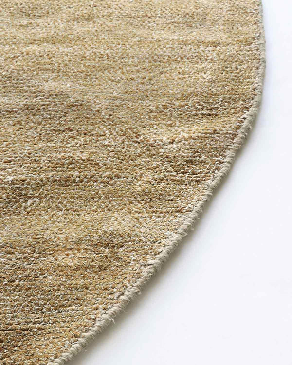 Close up view of edge of warm beige Sand Dune round floor rug by Baya NZ