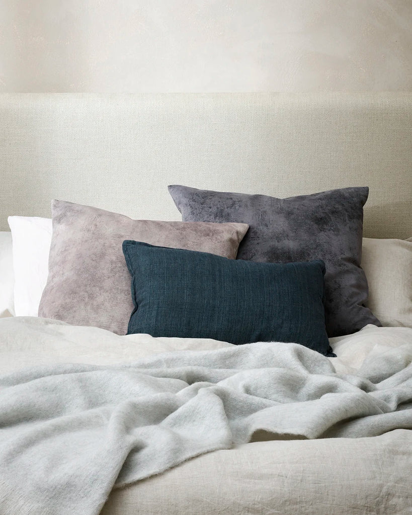 Baya theo velvet cushions on a bed in a contemporary bedroom setting