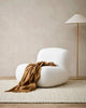 Brown throw blanket in colour 'cinnamon' draped on a seat in a contemporary living room