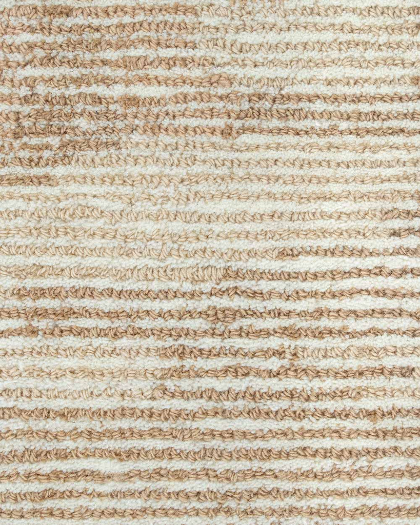 A detailed image of the weave of the Beckett floor rug by Baya, showing the different tones of beige, cream, and light brown, and loop styles, giving insight to how the pattern comes together. 