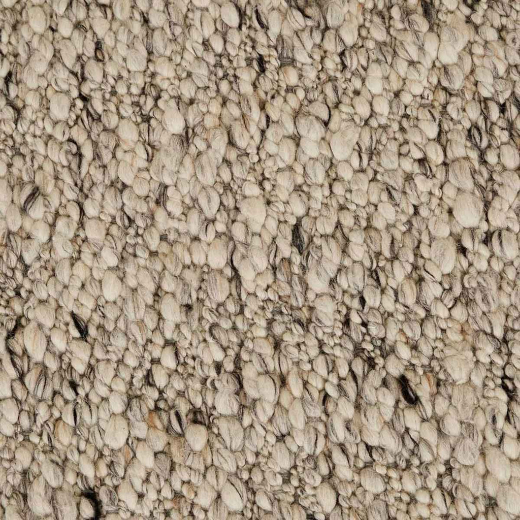 Close up of the weave of a textural wool blend boucle style rug by Globe West and Soren Liv NZ in shades of light grey and brown.
