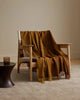 A two-toned caramel brown wool throw blanket draped over a chair