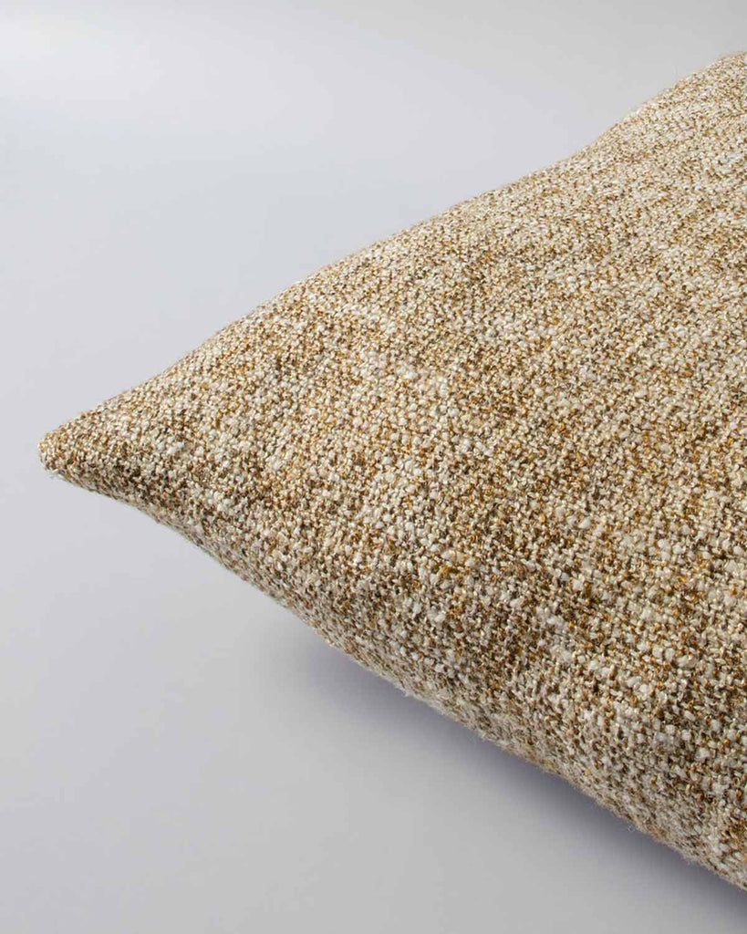 Corner view of a textural woven cushion in shades of muted mustard yellow and ercu, by Baya