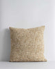 A textural woven cushion in shades of muted mustard yellow and ercu, by Baya