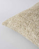 Corner view of a textural woven cushion in shades of creamy oat and ercu, by Baya