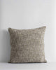 A textured woven cushion in shades of pebble brown and ercu, by Baya
